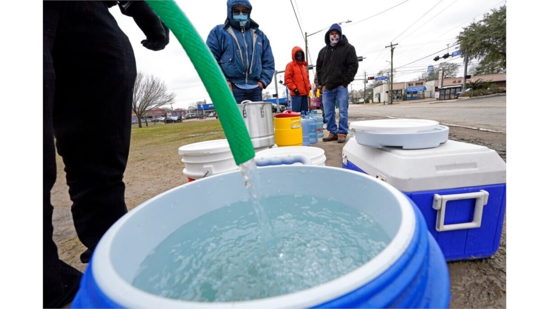 Se llena un barril de agua mientras otros esperan en temperaturas bajo cero para usar una manguera en el grifo de un parque en Houston, 18 de febrero de 2021. La electricidad volvió a Texas, pero muchos carecen de agua corriente.