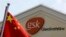 Chinese flag is hoisted in front of the GlaxoSmithKline building in Shanghai, July 24, 2013.