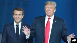 FILE — French President Emmanuel Macron, left, walks with former U.S. President Donald Trump at NATO headquarters in Brussels, July 11, 2018. During a town hall meeting last week, Trump refused to commit to U.S. membership of NATO if elected to a second term.