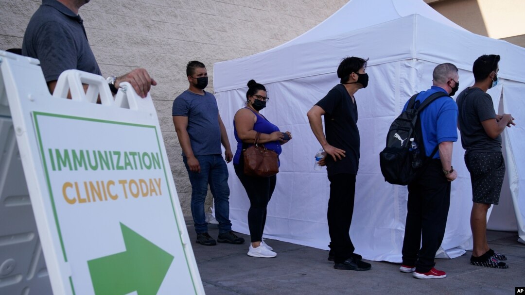 People wait in line for COVID-19 vaccinations at an event at La Bonita market, a Hispanic grocery store, July 7, 2021, in Las Vegas, as the areas with the lowest vaccination rates have the highest rates of new cases.