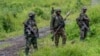 FILE - M23 rebels stand with their weapons in Kibumba, in the eastern of Democratic Republic of Congo, Dec. 23, 2022.