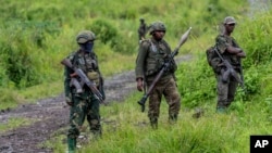 FILE - M23 rebels stand with their weapons in Kibumba, in the eastern of Democratic Republic of Congo, Dec. 23, 2022.