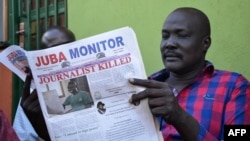 FILE - A man reads a copy of the Juba Monitor, with a heading referring to the killing of South Sudanese journalist Peter Moi of The New Nation newspaper, on August 21, 2015 in Juba.