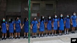 Para siswa yang mengenakan topeng berpegangan tangan, mengelilingi kampus St.Stephen's Girls di Hong Kong, Senin, 9 September 2019.