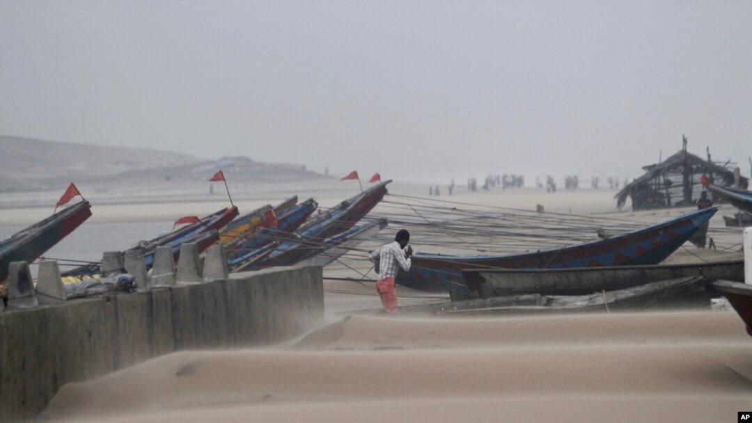 Seorang nelayan berjalan di dekat kapalnya yang sedang diikat di pelabuhan, saat angin kuat berhembus di pantai Gopalpur, wilayah Bengal, negara bagian Orissa, India (13/10).