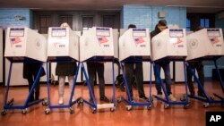 FILE - Voters fill out their forms at a polling station in the Brooklyn borough of New York, Nov. 8, 2016. Trailing Hillary Clinton in the popular vote count, President-elect Donald Trump's claims that "millions of people" voted illegally in the Nov. 8 election he won.