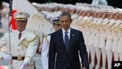 U.S. President Barack Obama, center, reviews an honor guard during a welcome ceremony at the Imperial Palace in Tokyo, Thursday, April 24, 2014. Facing fresh questions about his commitment to Asia, Obama will seek to convince Japan's leaders Thursday that he can deliver on his security and economic pledges, even as the crisis in Ukraine demands U.S. attention and resources elsewhere. (AP Photo/Shizuo Kambayashi, Pool)