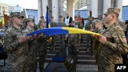 Los militares ucranianos sostienen la bandera ucraniana sobre el ataúd de Sergii Konoval durante la ceremonia de despedida de los militares ucranianos Sergii Konoval. [Foto: Archivo/AFP]