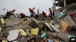 Des bénévoles à la recherche de survivants dans les ruines à Pedernales, Equateur, le 17 avril 2016.