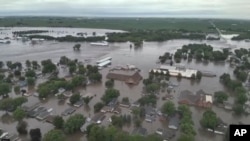 Esta imagen del sábado 22 de junio de 2024, proporcionada por la policía del condado Sioux, muestra la ciudad de Rock Valley, Iowa, inundada tras semanas de lluvias.