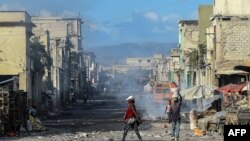 Orang-orang berjalan di jalan yang sepi menjelang penembakan geng di pusat kota di Port-au-Prince. (Foto: AFP)