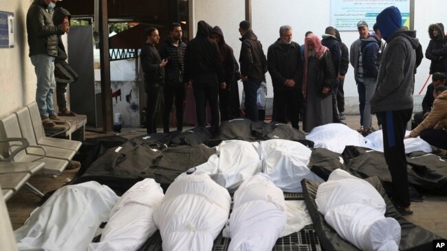 Palestinians stand around relatives killed in the Israeli bombardment of the Gaza Strip at a morgue in Rafah, Feb. 21, 2024.