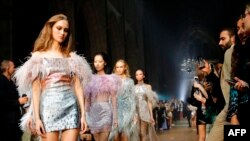 Models present creations from the 'Julien x Gabriela' collection by Julien Macdonald during a catwalk show for the Spring/Summer 2020 collection on the fourth day of London Fashion Week at Southwark Cathedral in London.
