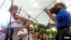 Several dozen of Alistair Fraser's camp students join him in a performance at the annual Scottish Gathering and Games in Pleasanton, California. (VOA/J Mar)