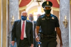 FILE - U.S. Postmaster General Louis DeJoy, left, is escorted to a meeting in House Speaker Nancy Pelosi's office on Capitol Hill in Washington, Aug. 5, 2020.