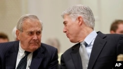 FILE - Supreme Court Justice Neil Gorsuch, right, talks with former Defense Secretary Donald Rumsfeld, right, at the 50th anniversary of the Fund for America Studies luncheon at the Trump Hotel in Washington, Thursday, Sept. 28, 2017. 