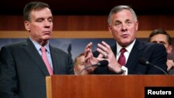 Ketua panel dari faksi Republik, Senator Richard Burr (kanan) memberi keterangan kepada media, didampingi Senator Mark Warner (kiri), ketua panel dari faksi Demokrat. 