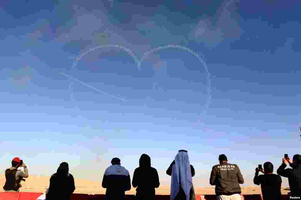 People watch as aircrafts perform during an airshow at Saudi Aviation Forum at Thumamah airport, in Riyadh, Saudi Arabia.