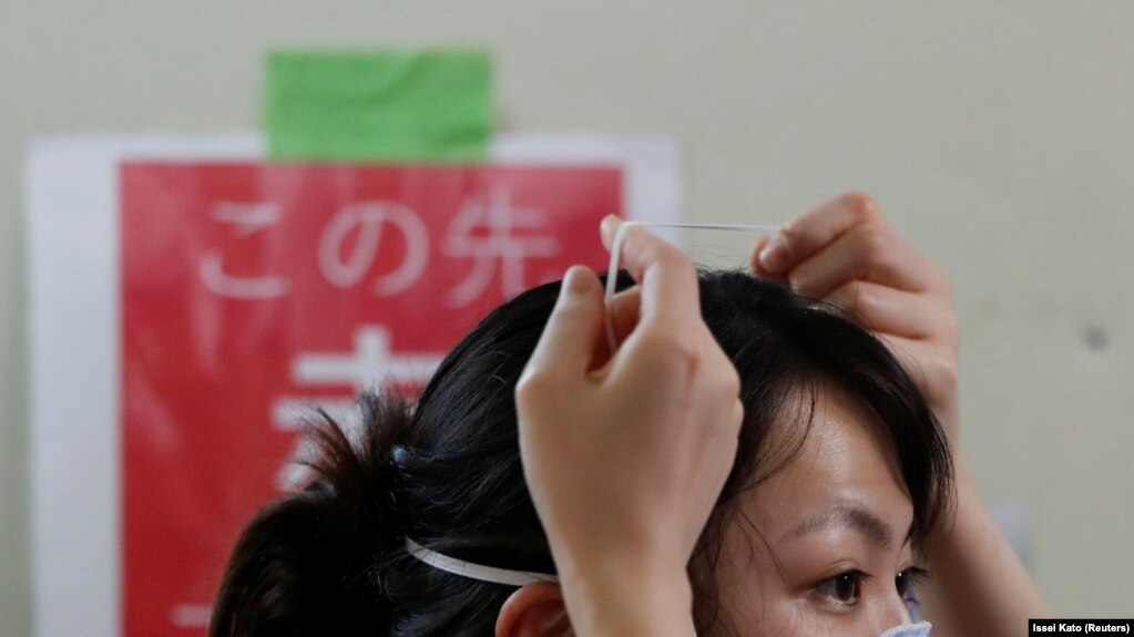 Un agent de santé enlève un masque de protection dans le service de soins intensifs pour les patients atteints de COVID-19 à l'hôpital universitaire St. Marianna à Kawasaki, au Japon, le 4 mai 2020.