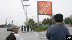 FILE - Only a few day laborers seek work near a skilled labor site at a Home Depot in Glendale, Calif. 