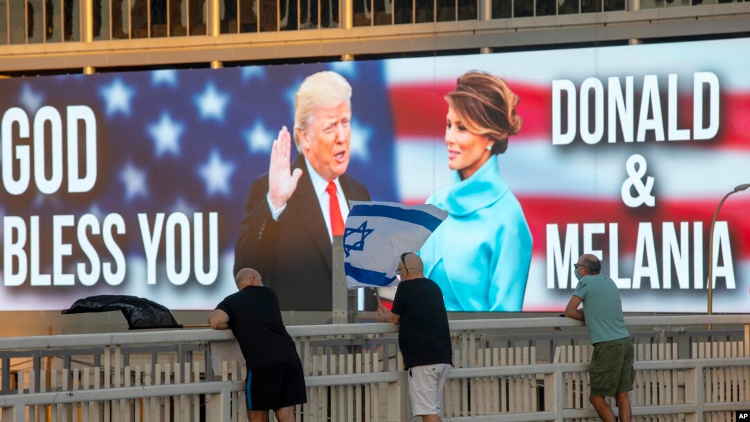 Papan reklame bergambar Presiden Donald Trump dan ibu negara Melania Trump, di dekat jembatan di Tel Aviv, Israel, Sabtu, 3 Oktober 2020. (AP Photo / Oded Balilty)