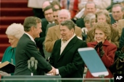 FILE - In this Jan. 20, 1989, photo, President George H.W. Bush, left, is congratulated by outgoing President Ronald Reagan after Bush took the oath of office as the 41st president of the United States on Capitol Hill in Washington.