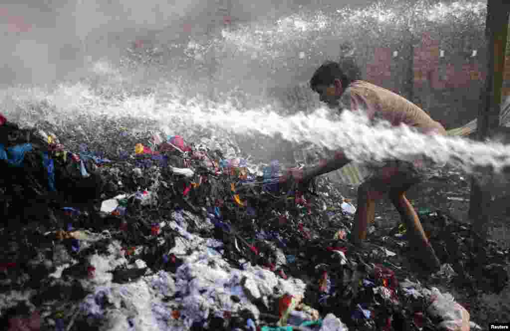 A man tries to retrieve items after a fire in a cotton warehouse in Dhaka, Bangladesh.