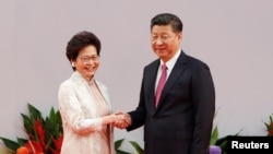 Presiden China XI JInping (kanan) berjabat tangan dengan Pemimpin Eksekutif Hong Kongyang baru saja dilantik, Carrie Lam, bertepatan dengan HUT ke-20 serah terima kekuasaan kawasan Hong Kong dari pemerintah Inggris ke pemerintah China di Hong Kong, China, 1 Juli 2017.