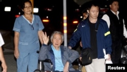 FILE - Former Peruvian President Alberto Fujimori accompanied by his son Kenji Fujimori (right) leaves the Centenario hospital in Lima, Peru, Jan. 4, 2018.