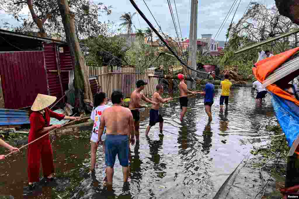 Warga setempat berusaha menyingkirkan pohon-pohon yang tumbang setelah Topan Yagi melanda kota Hai Phong, Vietnam. (Reuters)&nbsp;