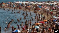 People sunbathe on a beach in Barcelona, Spain, Aug. 1, 2018. 