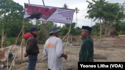 Sejumlah warga yang berada di lahan lokasi pemukiman baru yang akan didirikan 36 unit hunian tetap berupa rumah panggung Risha untuk 36 keluarga nelayan yang kehilangan rumah akibat terjangan tsunami teluk Palu. (Foto: VOA/Yoanes Litha)