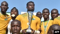 Les joueurs ivoiriens posent avec leur trophée après leur victoire contre le Nigeria lors du dernier match du championnat d'Afrique de rugby à sept à Abidjan, le 16 septembre 2018.