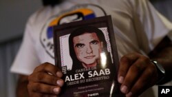 Un miembro del movimiento Liberen a Alex Saab sostiene una imagen de Alex Saab durante una conferencia de prensa en Caracas, el 15 de agosto de 2022.