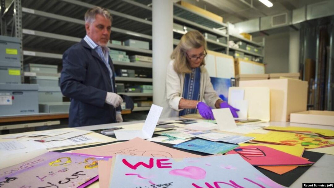 Jan Ramirez, chief curator at the 9/11 Memorial & Museum, right, sifts through a collection of condolence cards for a victim of 9/11 that were donated to the museum's archive, July 16, 2021, in Jersey City, New Jersey. (AP Photo/Robert Bumsted)