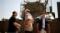 Israeli Defense Minister Moshe Yaalon (C) stands in front of an armored personnel carrier (APC) during a visit to a military base near Kibbutz Kissufim outside the central Gaza Strip, May 7, 2013.