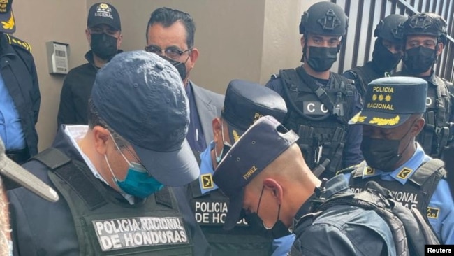 Oficiales de policía esposan al expresidente hondureño Juan Orlando Hernández después de ser detenido por miembros de la Policía Nacional de Honduras, en Tegucigalpa, Honduras, el 15 de febrero de 2022.