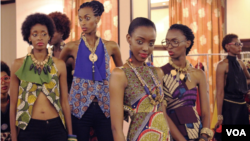 Models wearing East African designer wear prepare for a runway show in Kampala. May 17, 2014. (Hilary Heuler / VOA News)