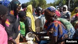 FILE - Cameroonians who fled deadly intercommunal violence between herders and farmers get food at a temporarily refugee camp on the outskirts of Ndjamena, Chad, Dec. 13, 2021. 