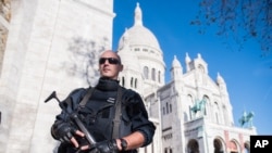 Seorang polisi Perancis mengamankan basilika "Sacre Coeur" di Paris, Minggu (15/11). Kelompok ISIS mengancam akan menjadikan Washington DC target serangan seperti Paris. 