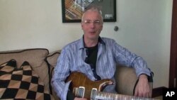 Paul Reed Smith holds one of the guitars he makes as he discusses what is involved in the craft - and art - of creating these customized instruments, June 2011