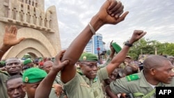 Colonel Malick Diaw, center, vice-president of the CNSP (National Committee for the Salvation of the People), gestures to supporters as he arrives escorted by Malian soldiers at the Independence Square in Bamako, Aug. 21, 2020. 