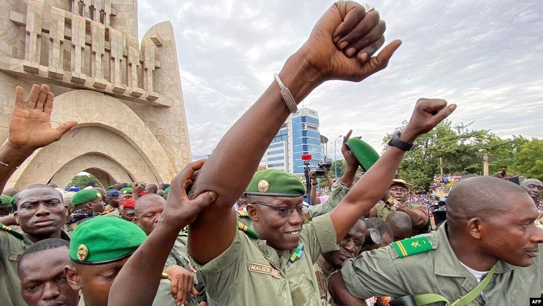 Colonel Malick Diaw, center, vice-president of the CNSP (National Committee for the Salvation of the People), gestures to supporters as Malian soldiers escort him through the Independence Square in Bamako, Aug. 21, 2020. 