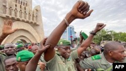 Colonel Malick Diaw, center, vice-president of the CNSP (National Committee for the Salvation of the People), gestures to supporters as Malian soldiers escort him through the Independence Square in Bamako, Aug. 21, 2020. 