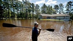 Residente de Linden, Carolina del Norte, se abre camino entre el agua después del desbordamiento de Little River.