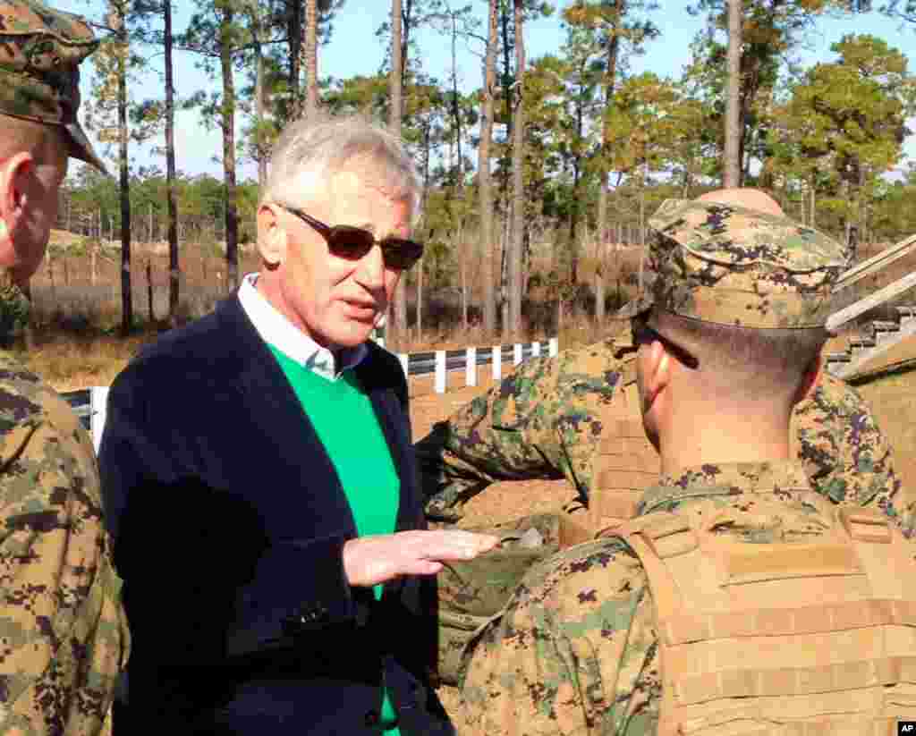 Defense Secretary Chuck Hagel talks to marines at a training range as he observes an experimental infantry unit that is going to help assess which combat jobs can be opened to women in 2016, Camp Lejeune, North Carolina, Nov. 18, 2014.