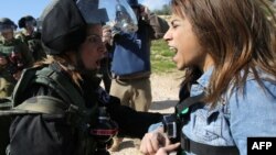 FILE - Palestinian activist Lema Nazeeh argues with an Israeli soldier following a protest march against Israeli settlements, near the West Bank village of Bilin, Jan. 30, 2015.