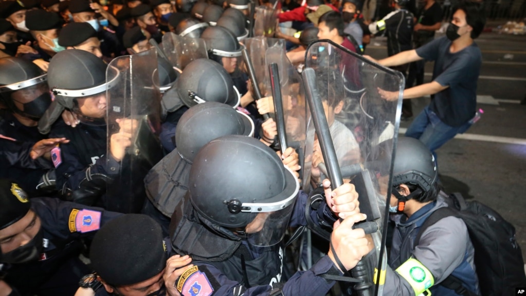 Pro-democracy protesters push Thai policemen with riot shields during a demonstration in Bangkok, Thailand, Thursday, Oct. 15, 2020. (AP Photo)