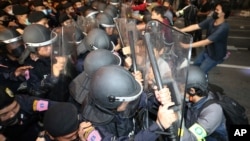 Pro-democracy protesters push Thai policemen with riot shields during a demonstration in Bangkok, Thailand, Thursday, Oct. 15, 2020. (AP Photo)