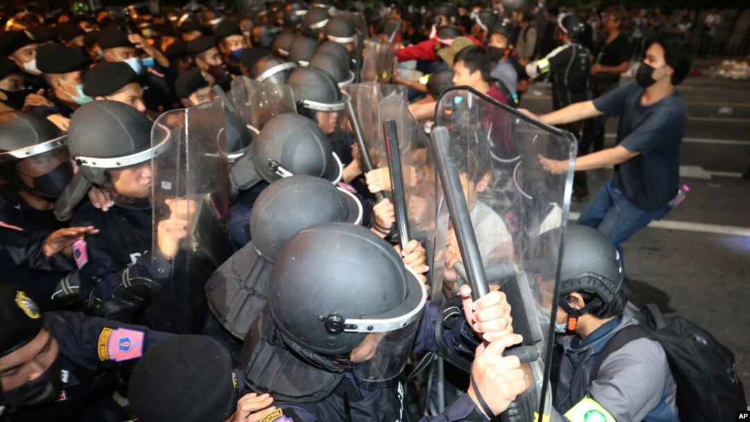 Pro-democracy protesters push Thai policemen with riot shields during a demonstration in Bangkok, Thailand, Thursday, Oct. 15, 2020. Thai police dispersed a group of protesters holding an overnight rally outside the prime minister's office. (AP…